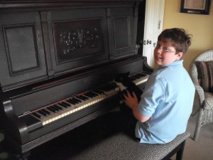 Logan giving LJ piano lessons